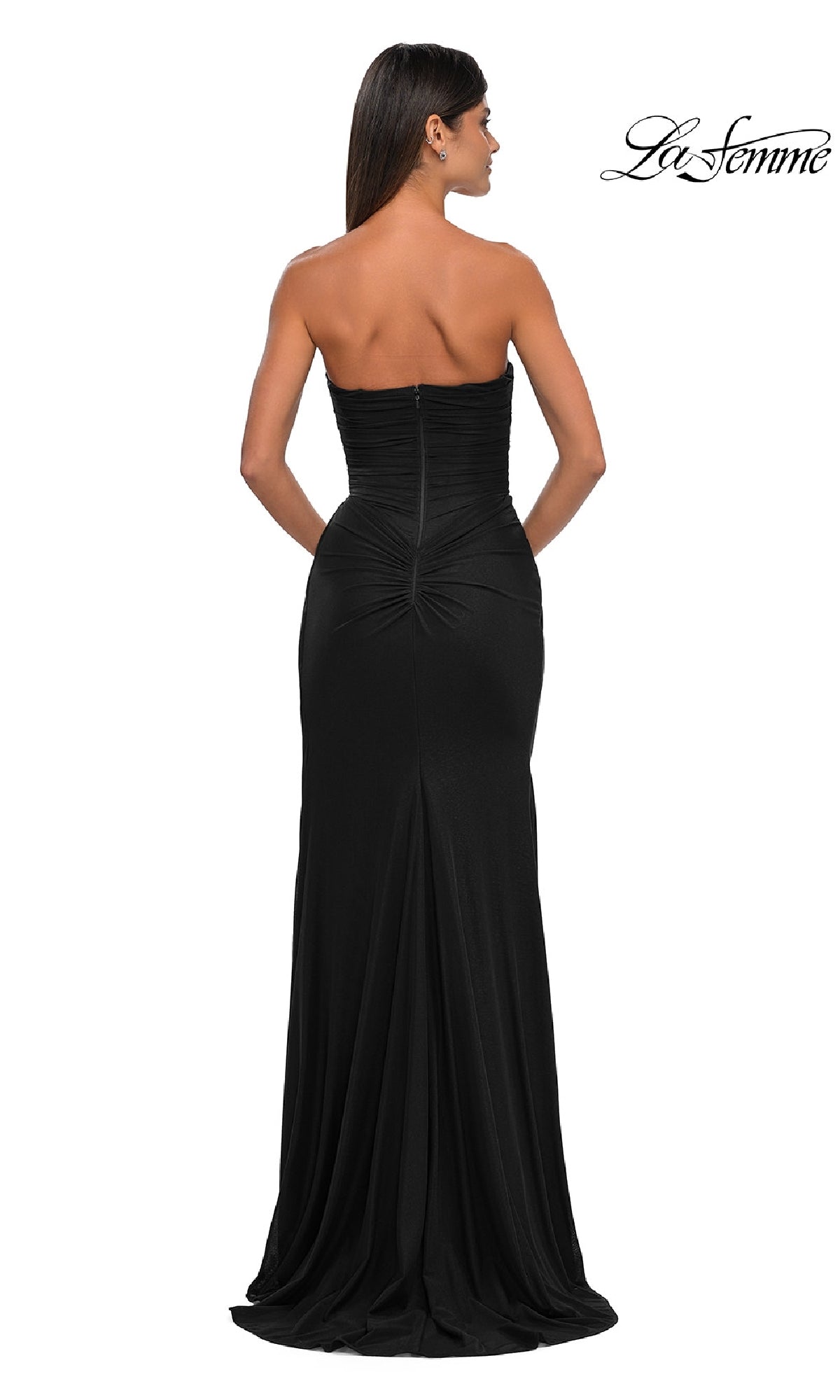 A woman stands with her back to the camera in the Classic Strapless Long Prom Dress: La Femme 33116, featuring a sweetheart neckline, fitted bodice, and floor-length skirt. The